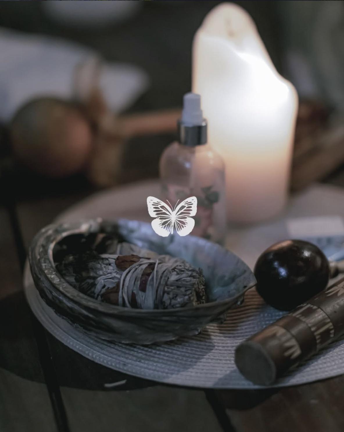 Altar de ceremonia con vela encendida, salvia y cuarzos